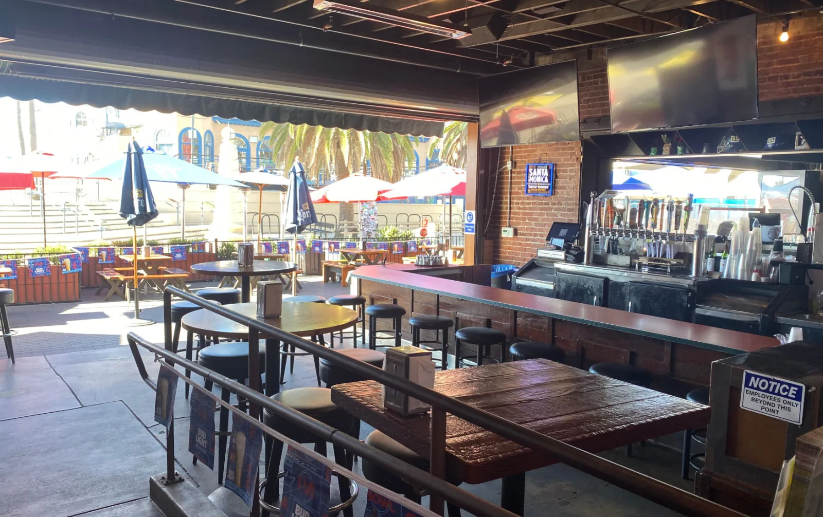 Big Dean's neon sign over a crowded bar, with the beach visible through the windows