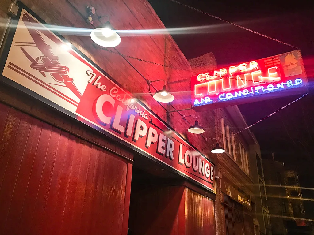 The California Clipper Lounge airplane sign and Clipper Lounge Air Conditioned neon at night