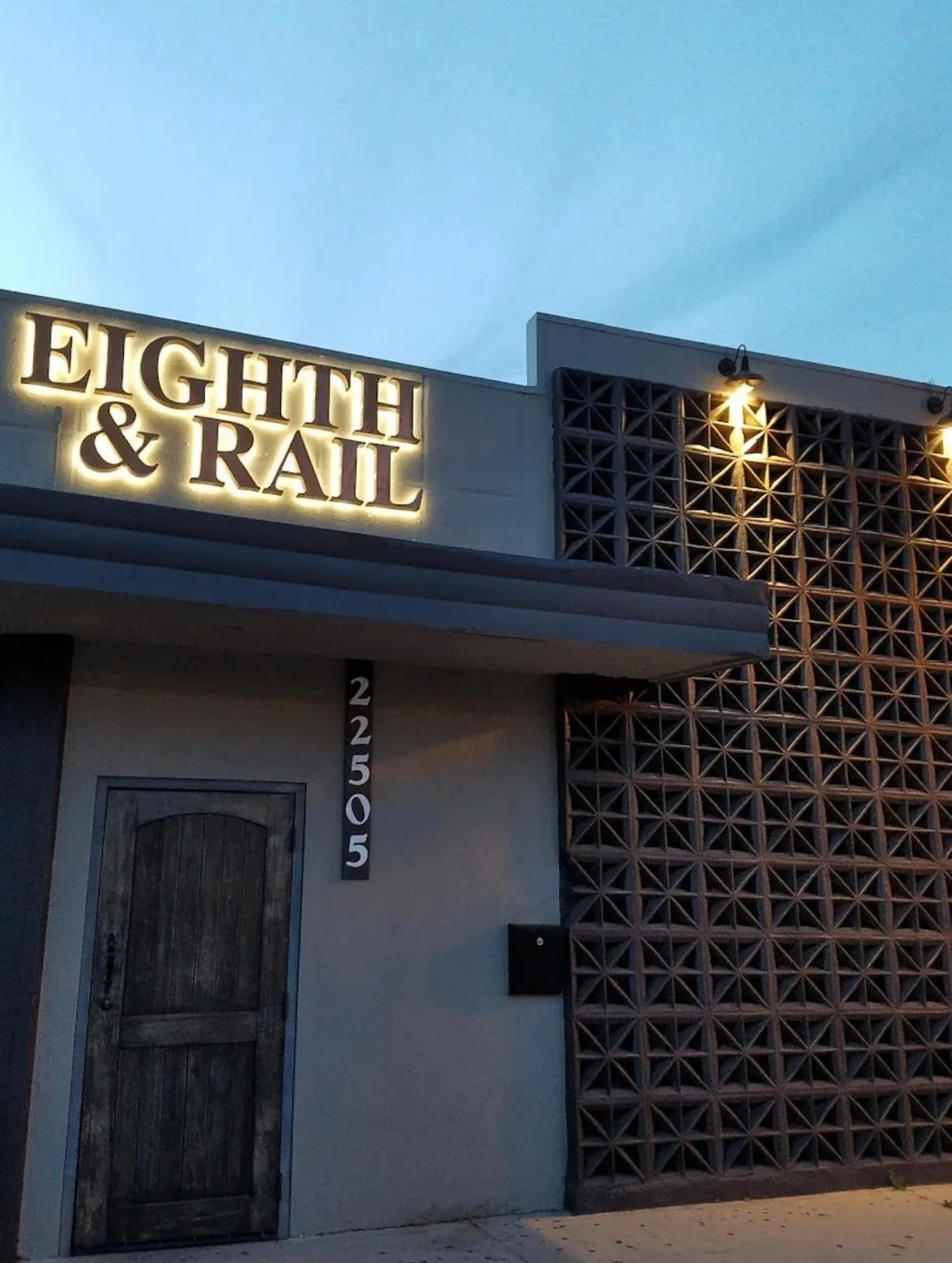 Eighth & Rail's brick storefront with a hanging RAIL sign and a beer-can sculpture by the door