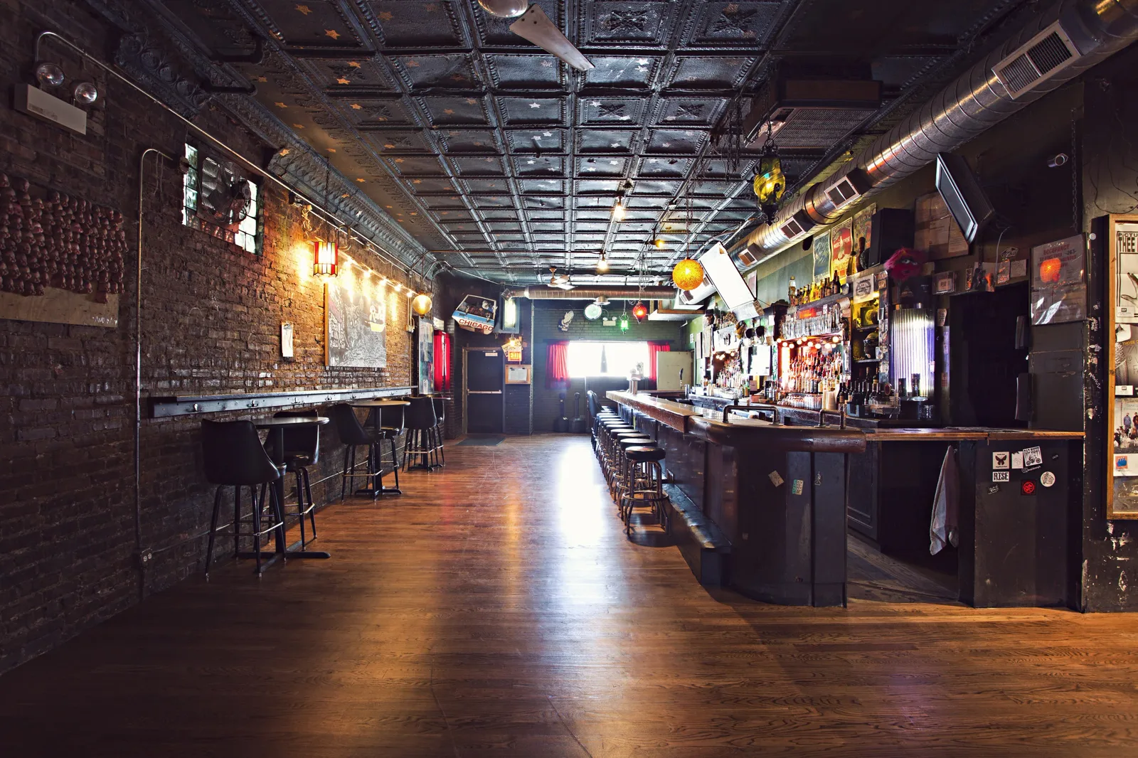The Empty Bottle shotgun room, with a wooden rail on the right and brick wall tables on the left
