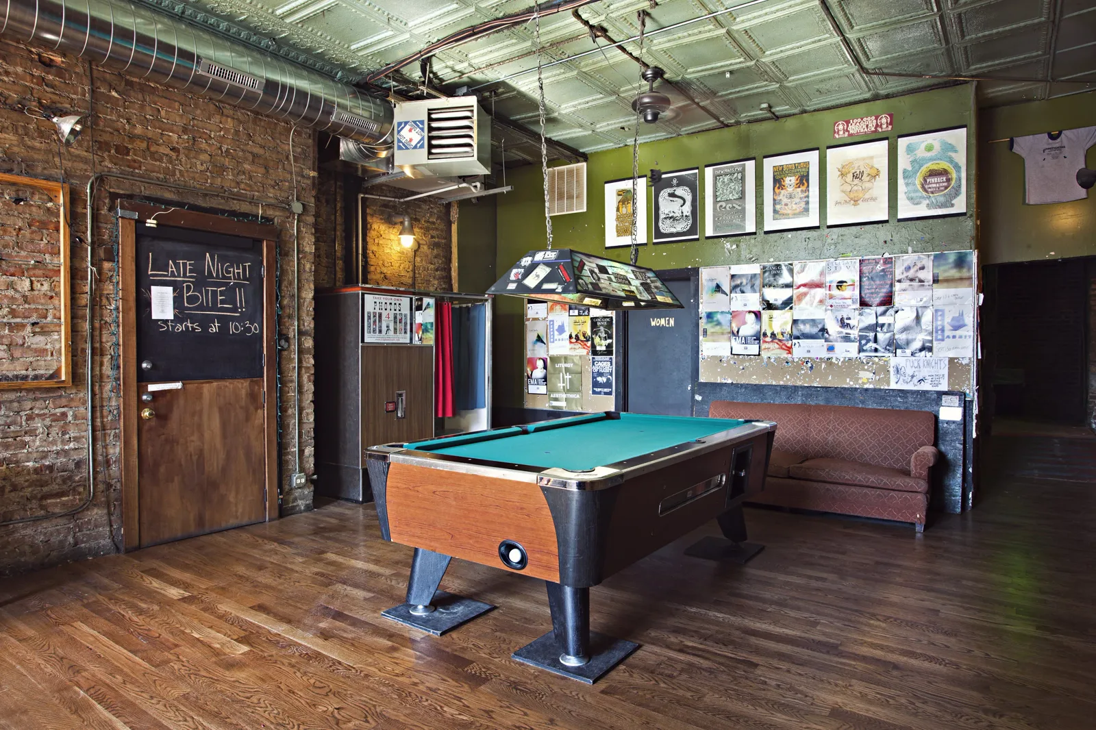 The Empty Bottle pool table, stickered light, tin ceiling, and flyer-covered back wall