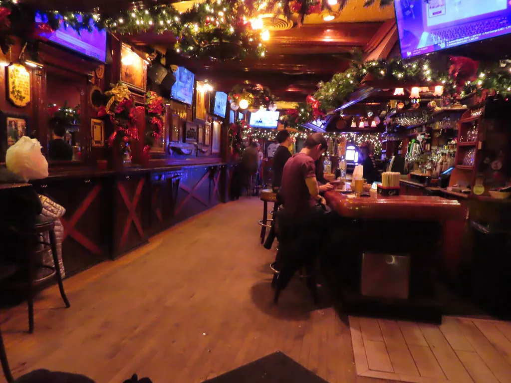 Evergreen garlands, red bows, and a packed rail inside Lodge Tavern on Division Street