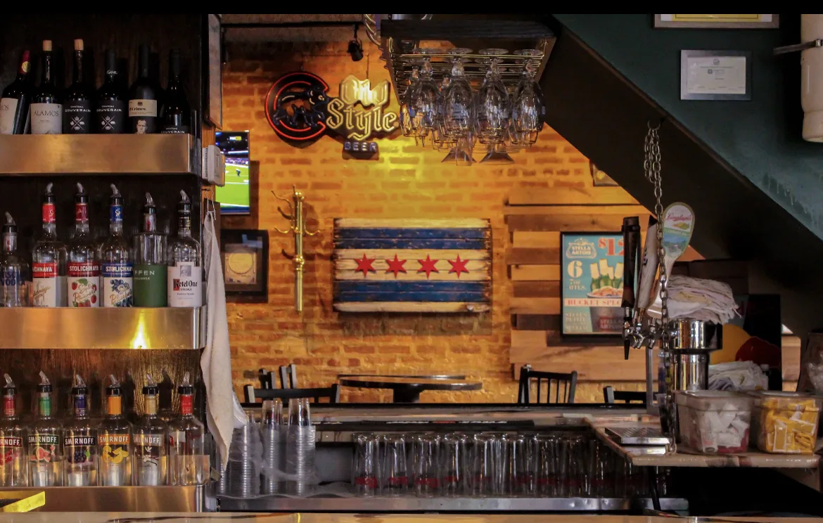 The wood rail, taps, and Cubs Old Style neon inside Paddy Mac's