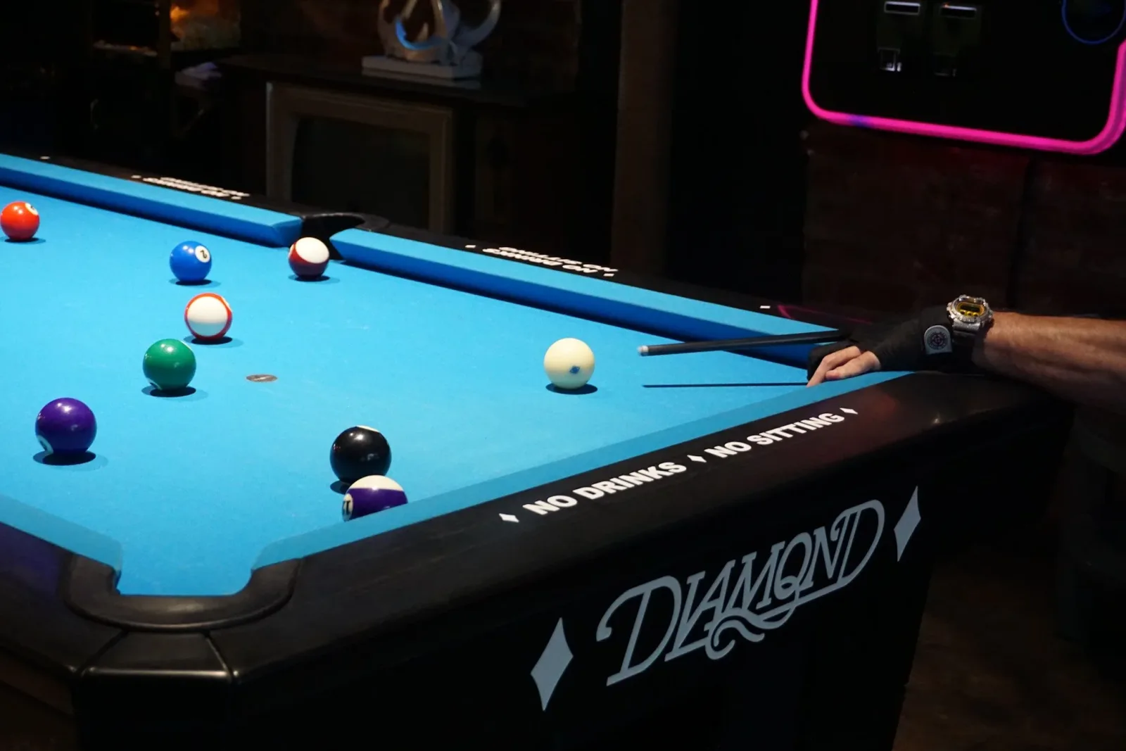 Port City Tavern bar with a pool table, neon beer signs, and wood paneling