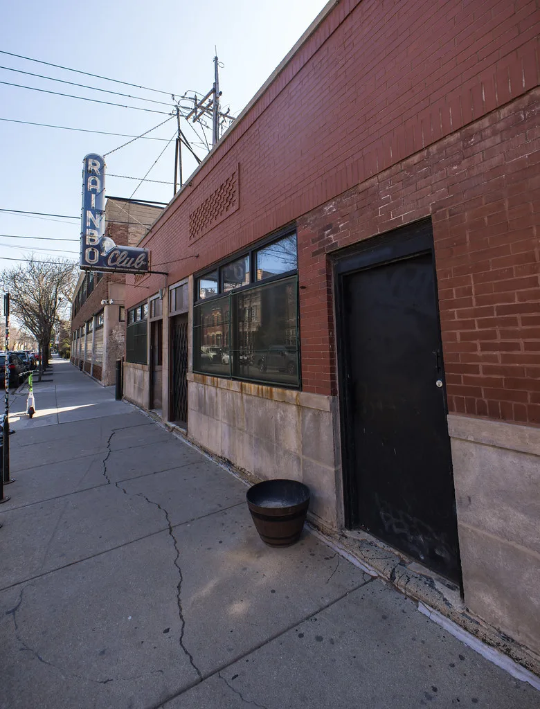 The vintage Rainbo Club neon sign along the sidewalk