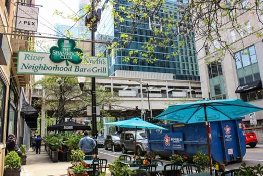The Shamrock Club sidewalk patio, hanging shamrock sign, and the elevated tracks in River North