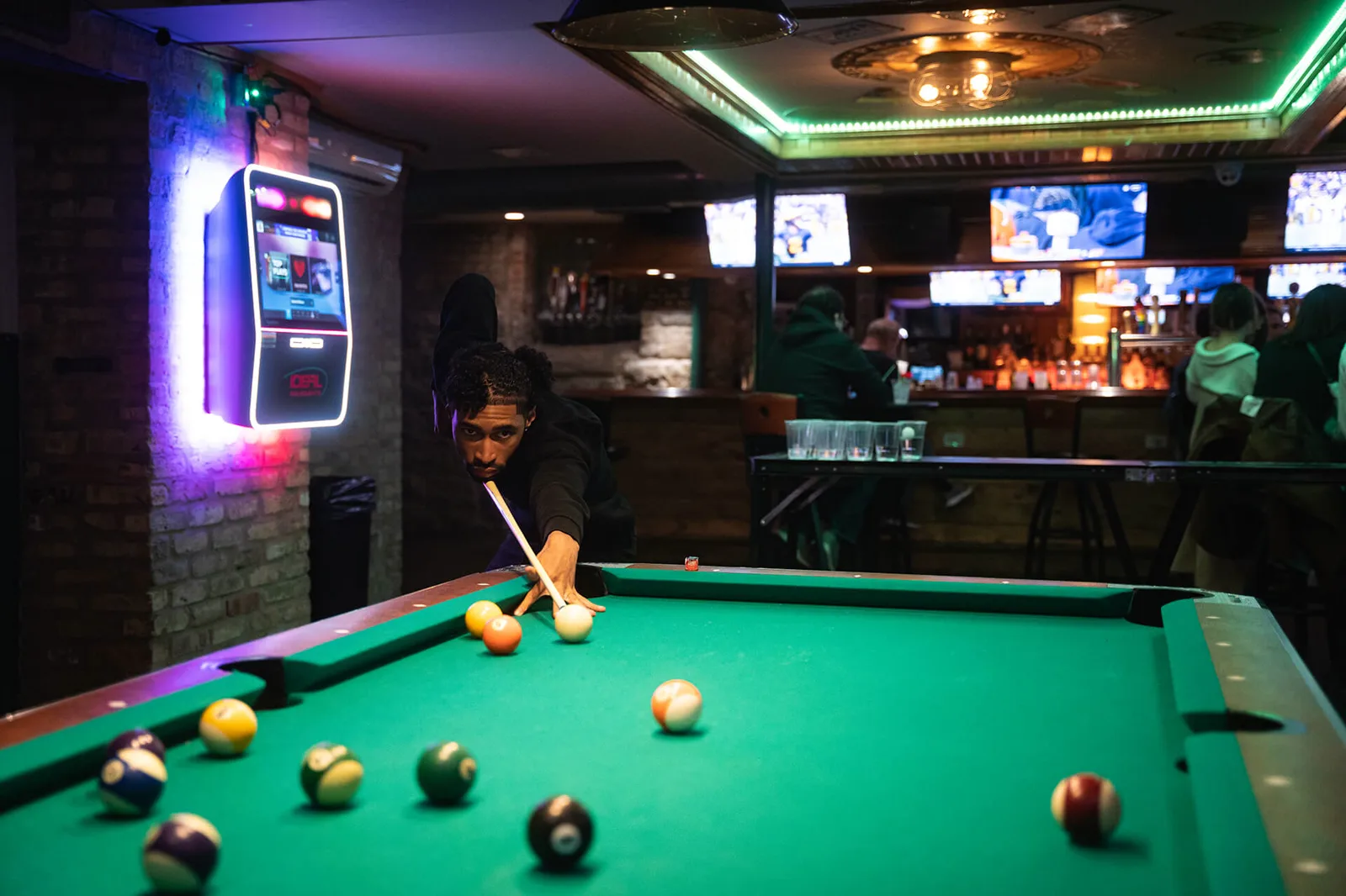 The pool table, neon jukebox, and brick-wall barroom at Streeter's Tavern