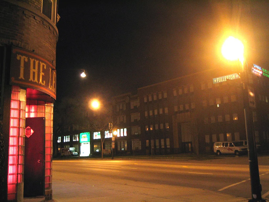 The Levee's glass-block doorway glowing red at night on West Fullerton Avenue
