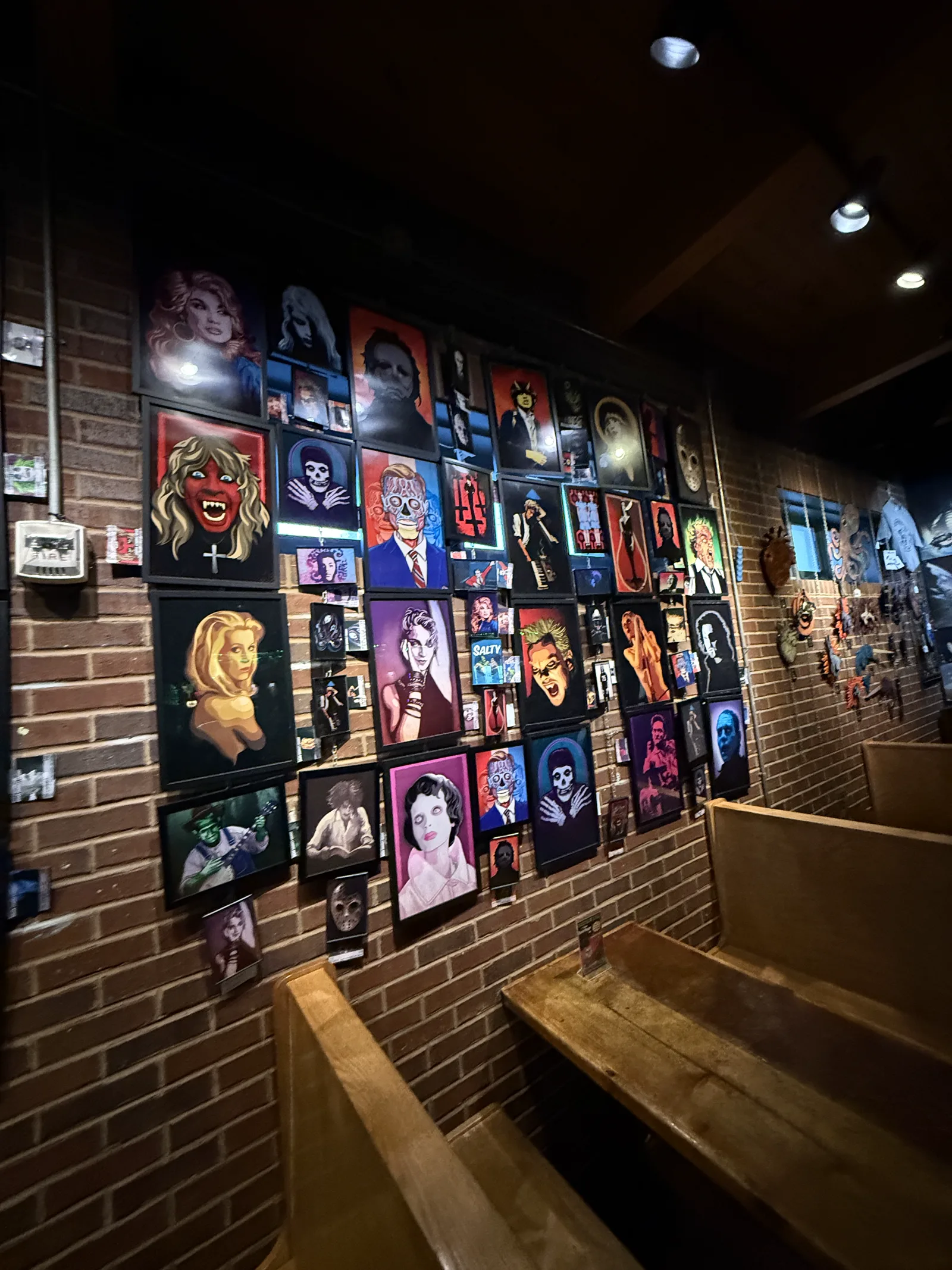 Wooden booths facing Trackside Tavern gallery wall of cult portraits