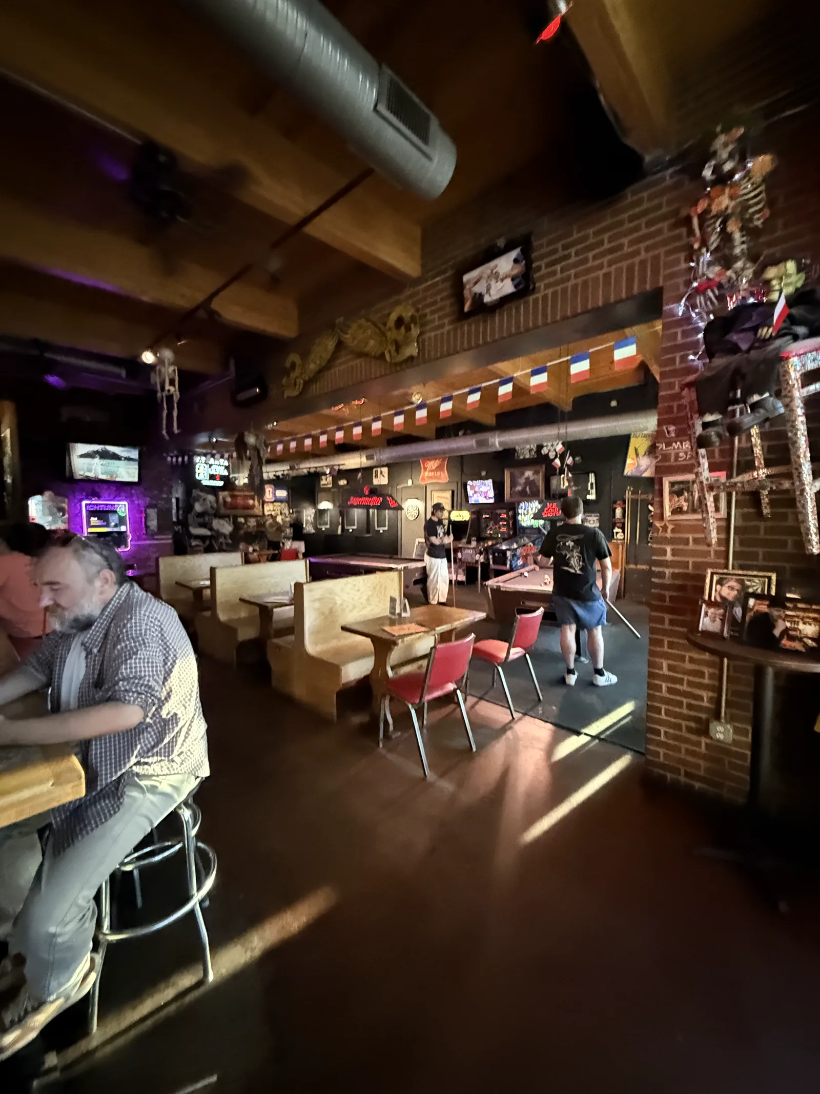 Sunlit floor, booths, and the pool tables in the back room at Trackside Tavern